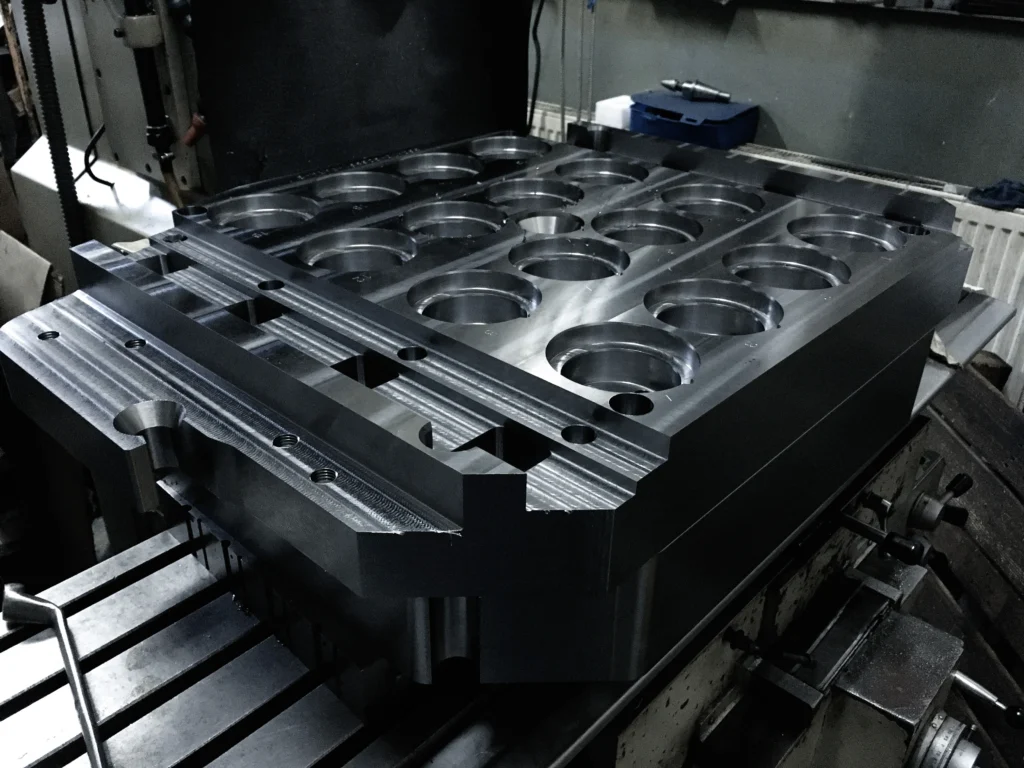 injection mold cavity plate a mold plate being machined at a mold manufacturer in a cnc milling machine.