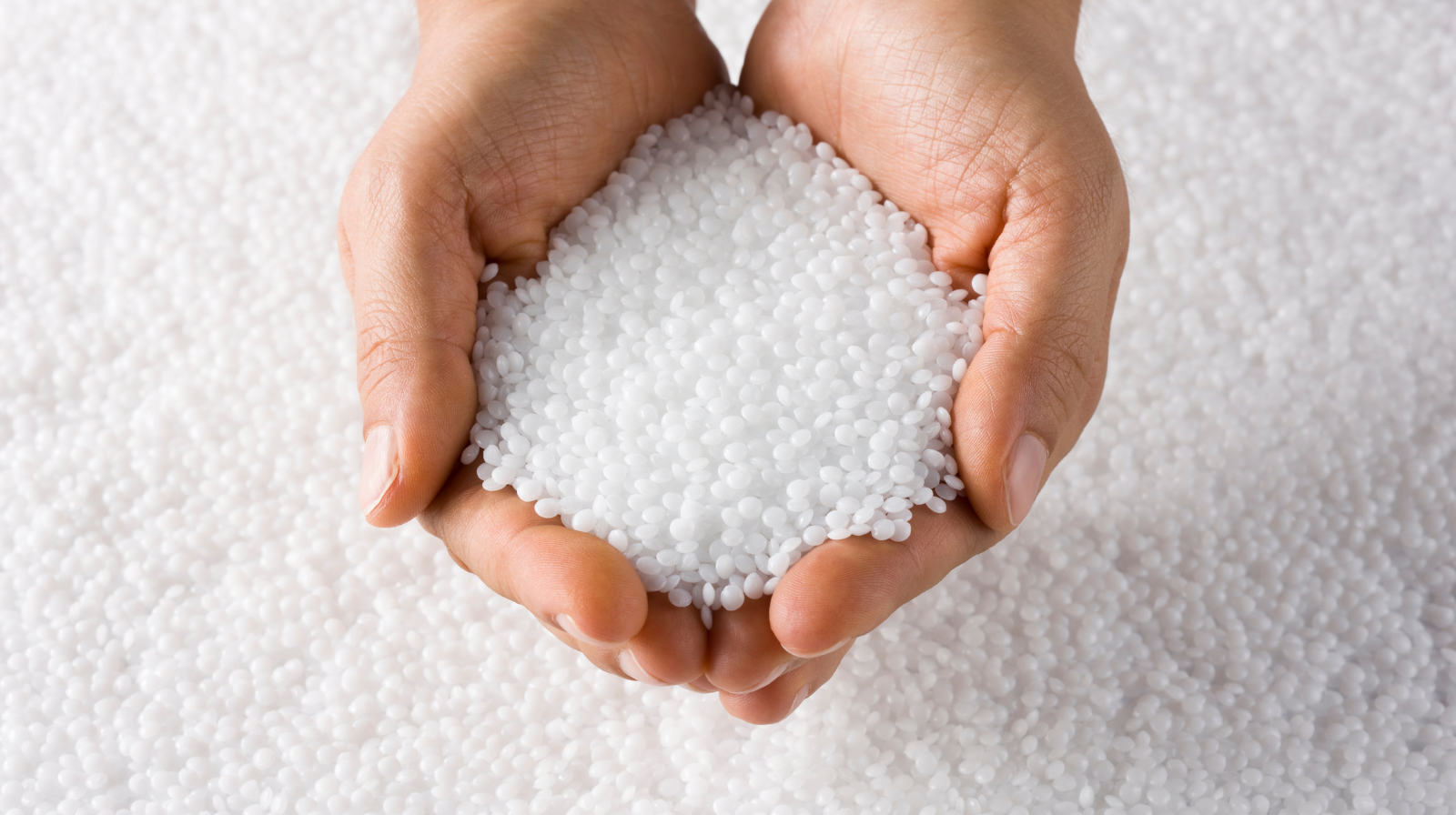 Close-up of high-flow plastic pellets used for injection molding.